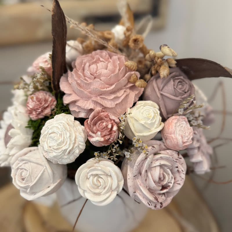 Composition de roses et pivoines en gypse rose poudré et blanc, avec mousse et fleurs séchées, sur une rondelle de bois